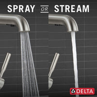 Modern brushed steel kitchen faucet beside utility sink