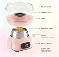 Pink candy floss maker displayed at a birthday party dessert table with fluffy cotton candy.