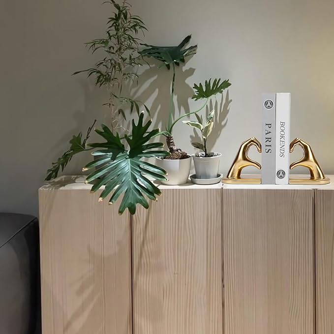 Gold hand sculpture book holder arranged on an office desk