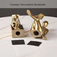 Gold ceramic bookends displayed on a modern living room shelf