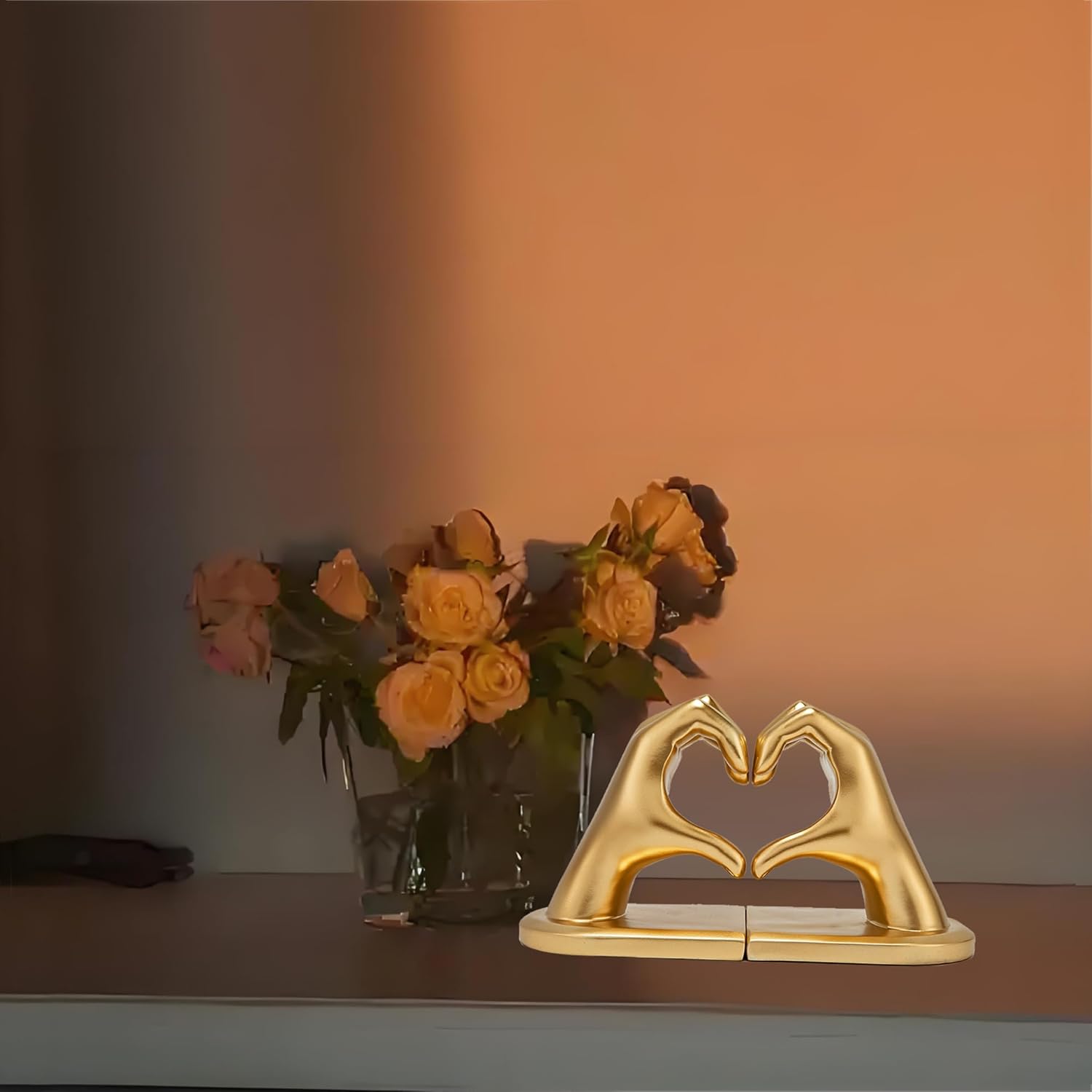 Gold hand-shaped bookends supporting books on a shelf