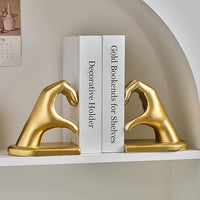 Gold hand sculpture used as modern shelf decoration