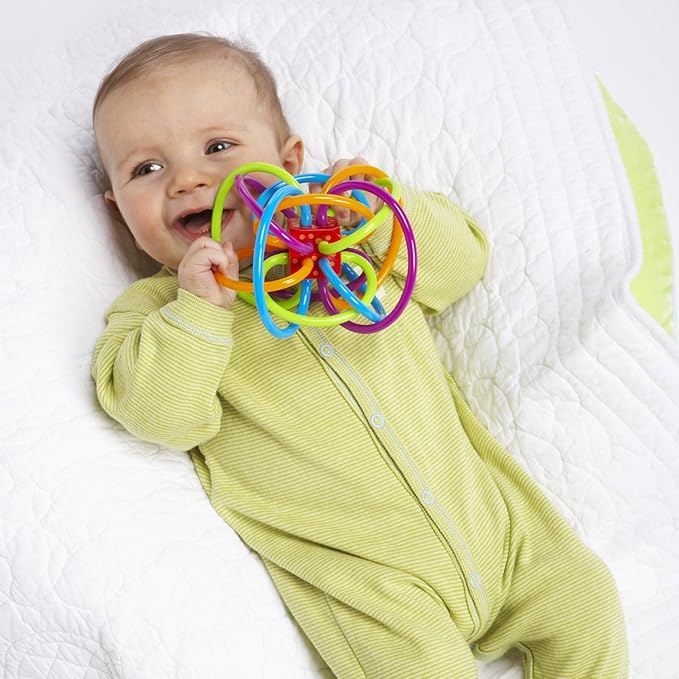 Infant holding teething and sensory rattle toy