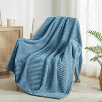 Soft slate blue waffle textured fleece blanket on couch