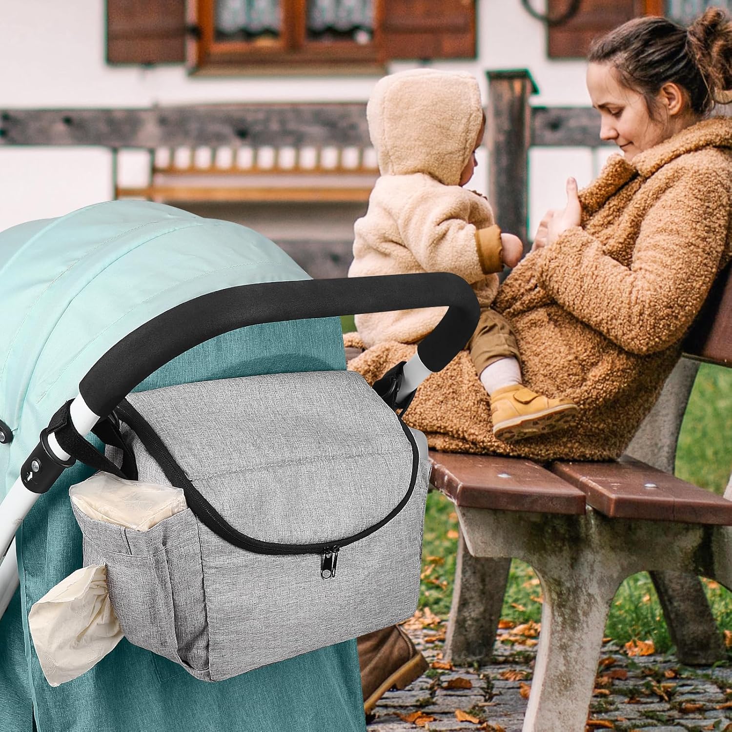 Neutral-colored stroller organizer bag with adjustable straps and shoulder strap.