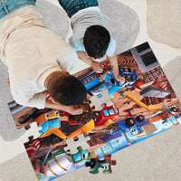 Two children playing with a train-themed puzzle on a large mat.