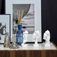 Three abstract resin figurines displayed on a clean office desk