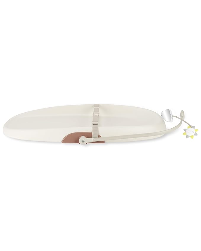 Contoured changing pad placed on a wooden nursery dresser top