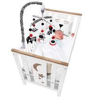 Black and white baby mobile installed above nursery crib