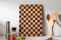 Checkered cutting board featuring an edge juice groove