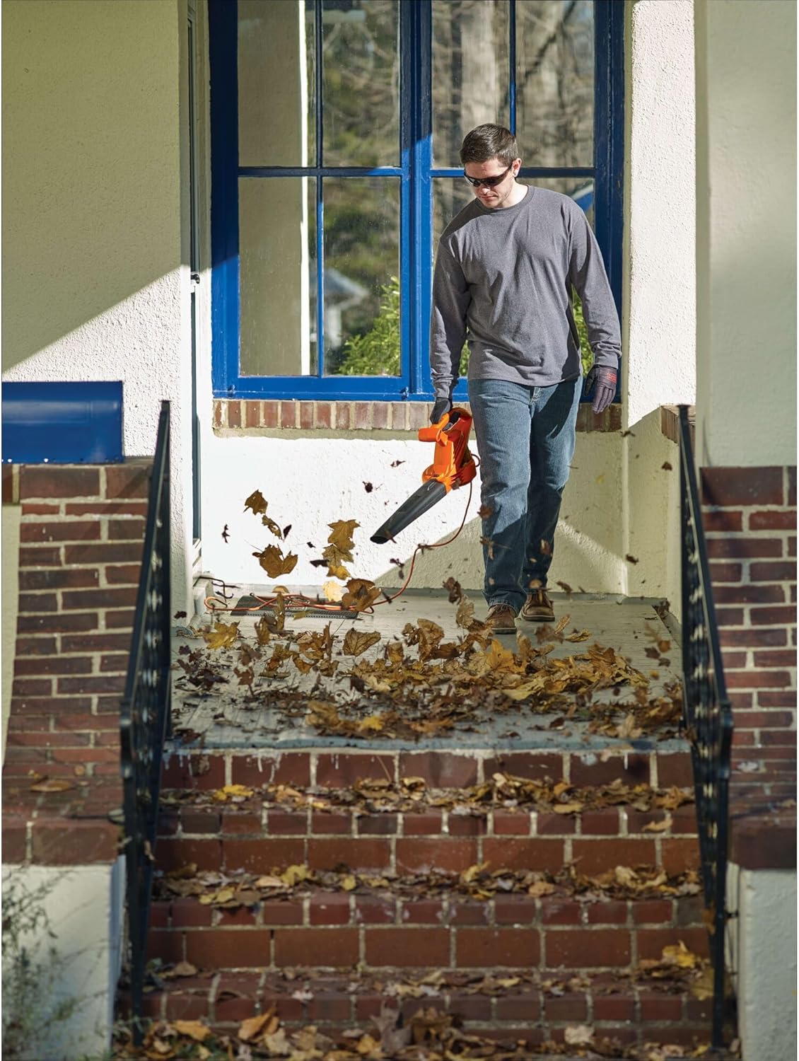Corded leaf blower with 180 CFM airflow used for clearing debris from a driveway.