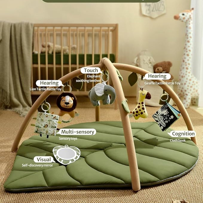 Infant enjoying tummy time on a soft activity mat beneath a wooden-style play gym