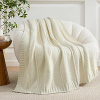 Ivory chenille throw blanket draped over a modern couch