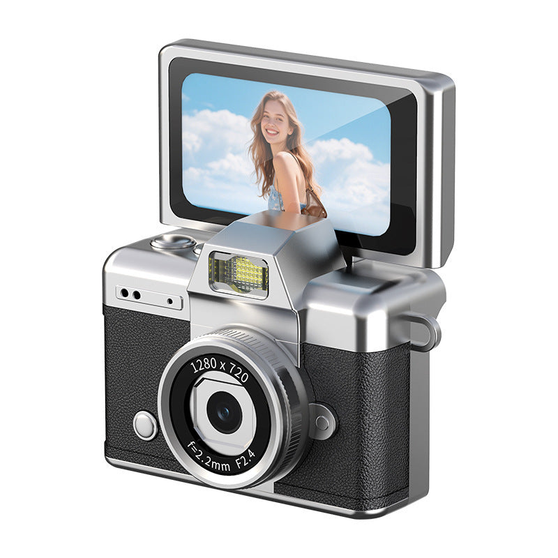 Silver-and-brown portable digital camera displayed on a clean desk beside everyday travel accessories.
