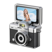 Silver-and-brown portable digital camera displayed on a clean desk beside everyday travel accessories.