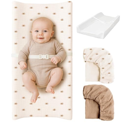 Pink muslin changing pad with two cotton covers on a white wooden nursery dresser