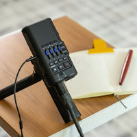 Portable audio interface placed on a desktop with microphone and headphones