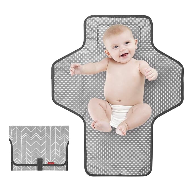 Compact folded gray travel changing pad with a black carry handle