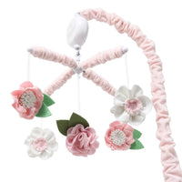 Rotating pink nursery mobile above a baby crib