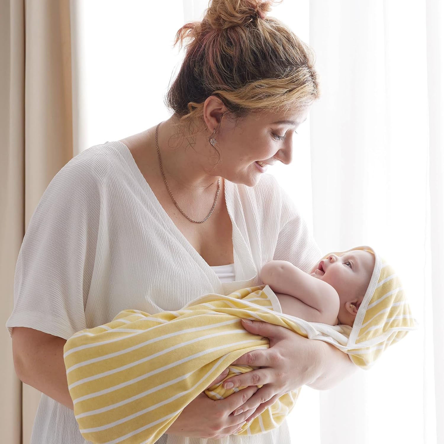 Toddler wrapped in hooded baby bath towel after swim or bath