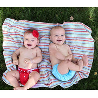 Various patterned cloth diaper covers hanging on a washing line to dry outdoors
