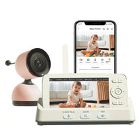Pink baby monitor camera with cream parent display and smartphone showing a baby playing