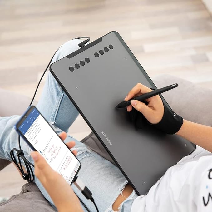 Artist using XPPen Deco 01 V3 tablet for digital illustration on laptop